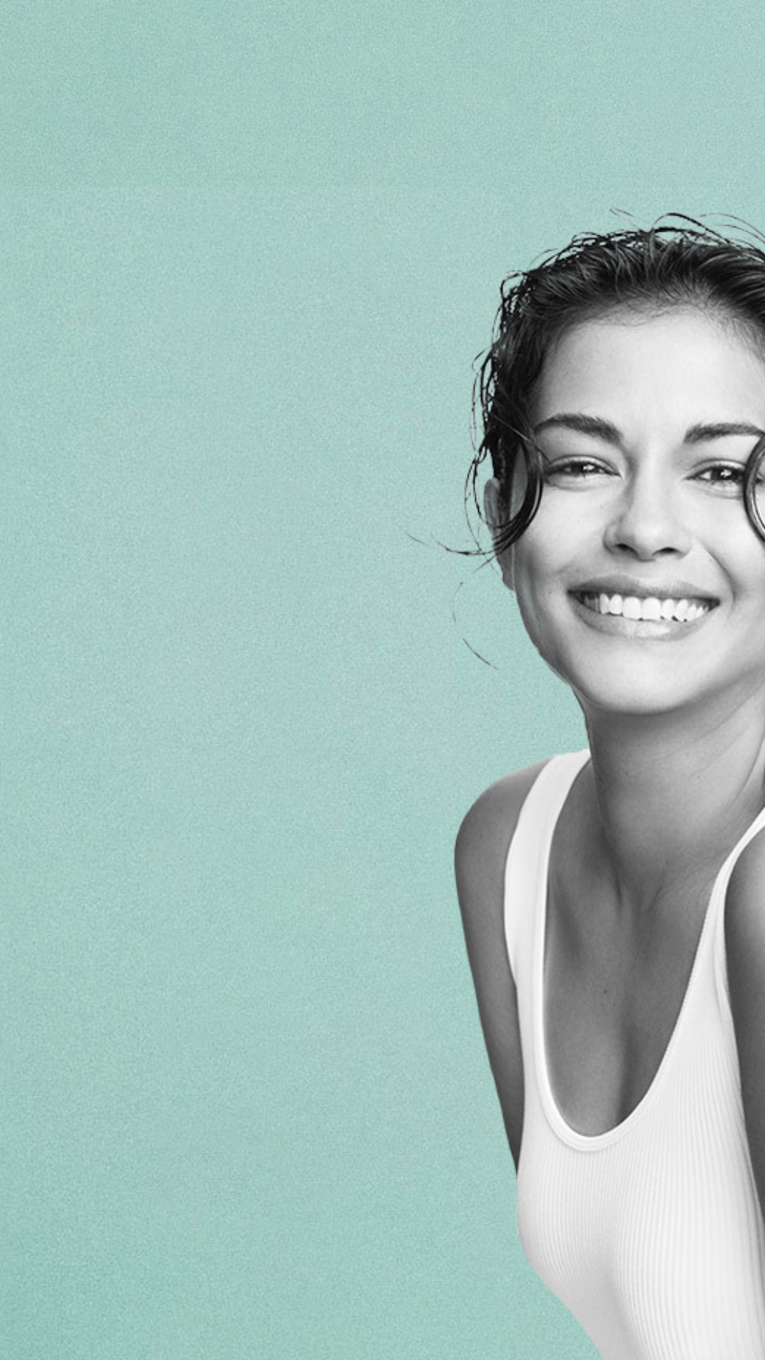 Woman in a white tank top smiling in a green background